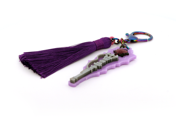 Viktor's Hex Cane in a miniature bag-charm form. The back features an etching of his assistive cane from season 1 of Arcane.